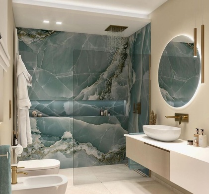 We built a new walk-in shower with green marble walls. We added a floating sink, gold fixtures, and a lit mirror.
